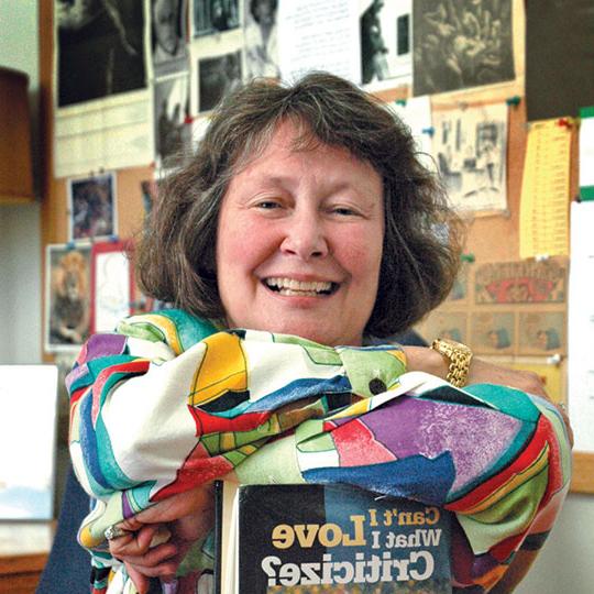 headshot of woman smiling and holding a book